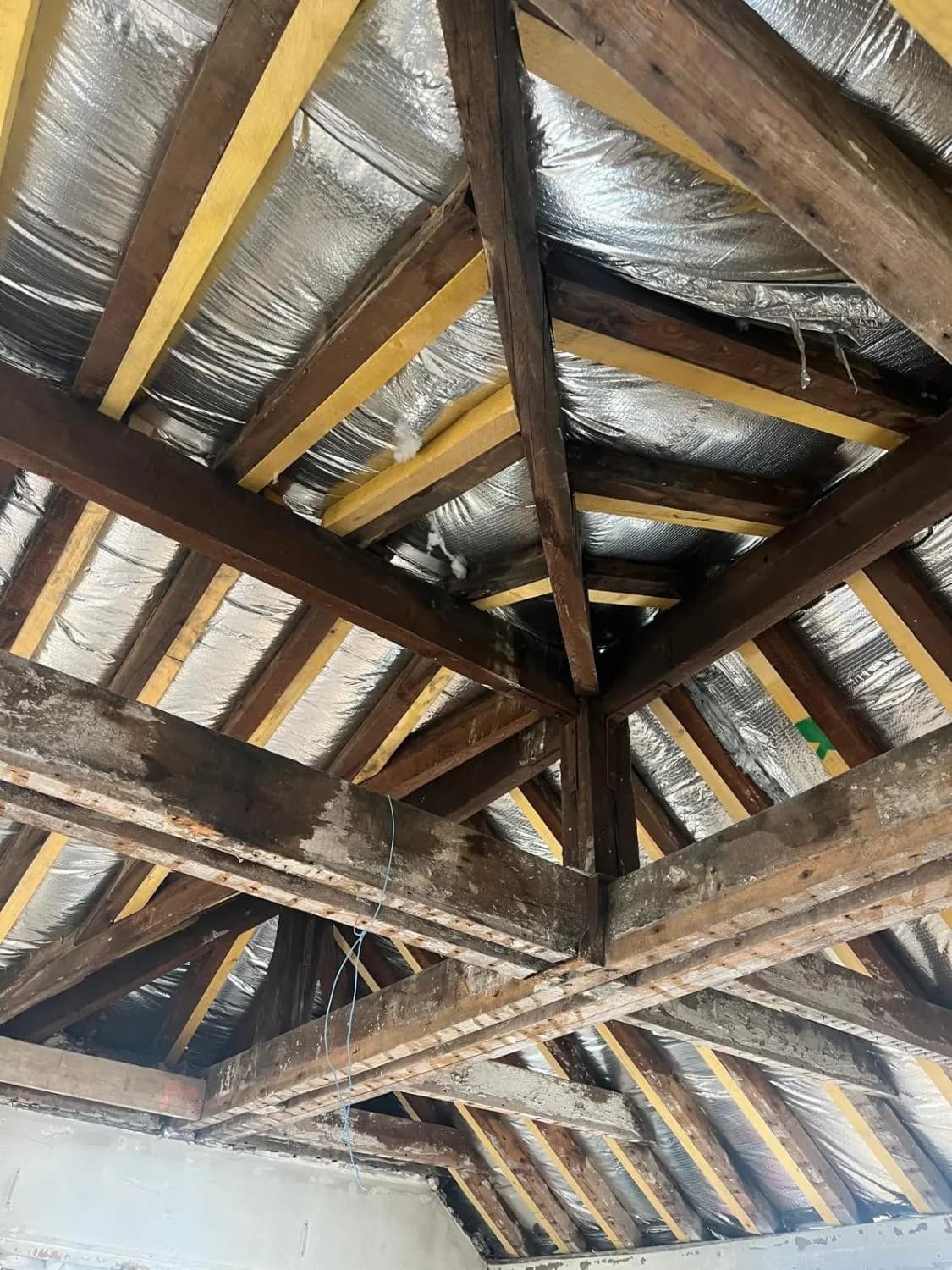 Charpente en bois mise à nu dans les combles pendant la rénovation