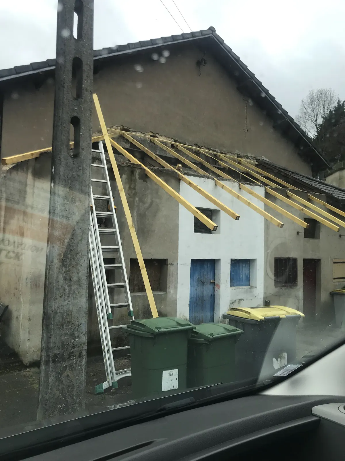 Charpente neuve en cours de pose sur une petite maison, échelle contre le mur