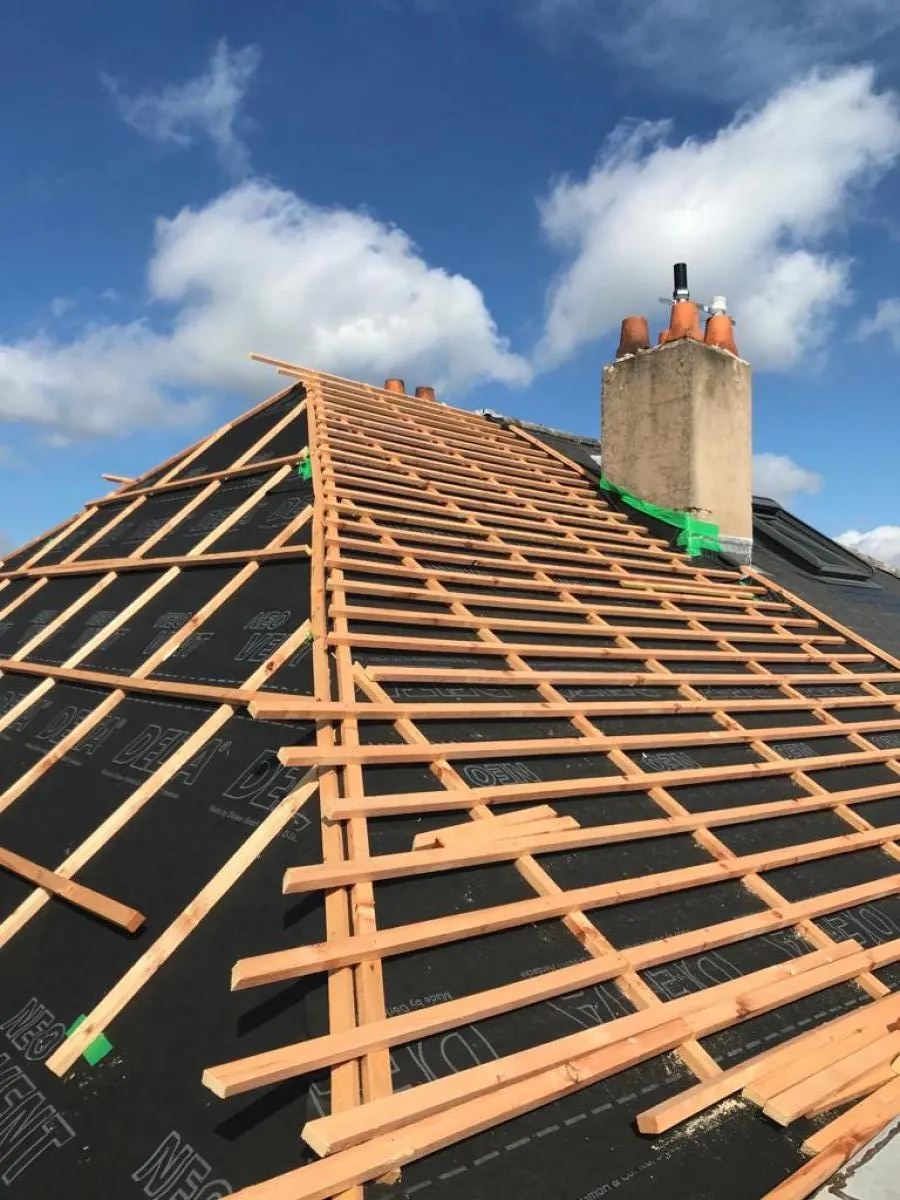 Liteaux neufs posés sur l’écran sous-toiture pendant une réfection