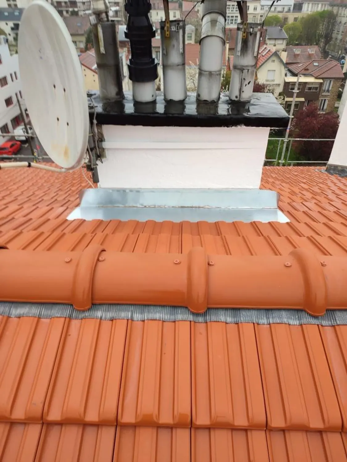 Solin en zinc au pied d’une souche sur une toiture en tuiles neuves